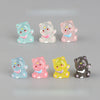 A collection of six pink and white cat-shaped resin keychains in various colors and finishes.