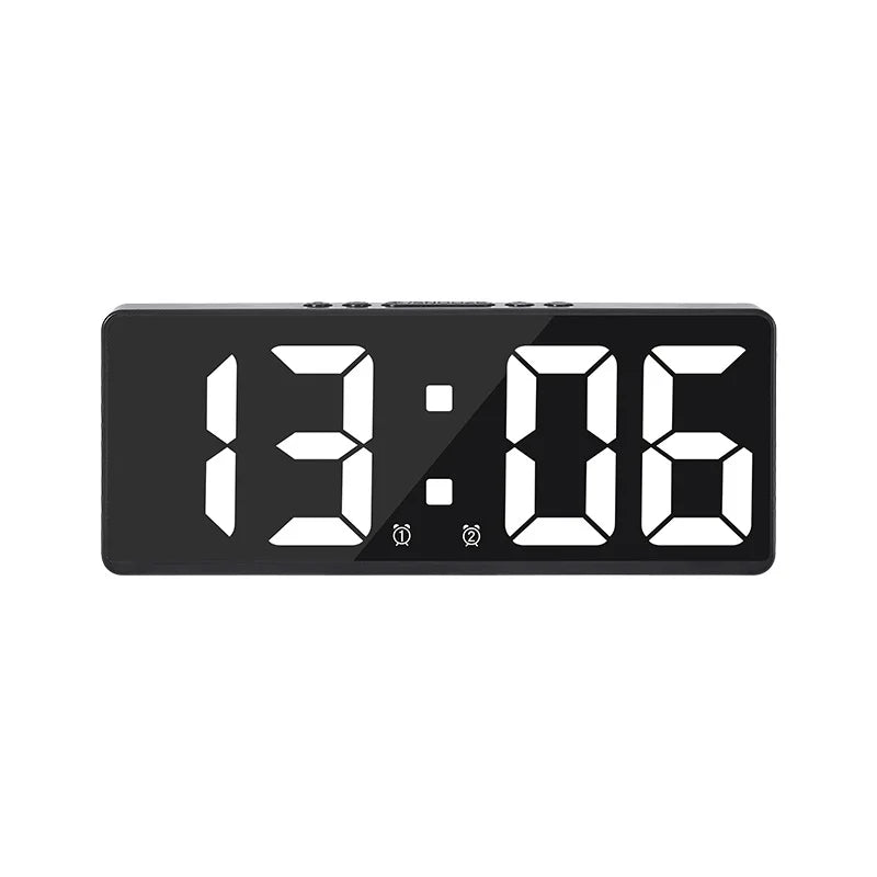 A black digital alarm clock displaying the time 13:06.