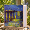 A photo album featuring a painting of reflections on water with yellow and green light against a dark blue sky.
