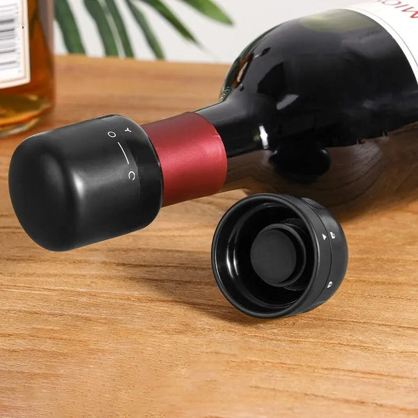 A black and red silicone wine bottle stopper is shown resting on a wooden surface.