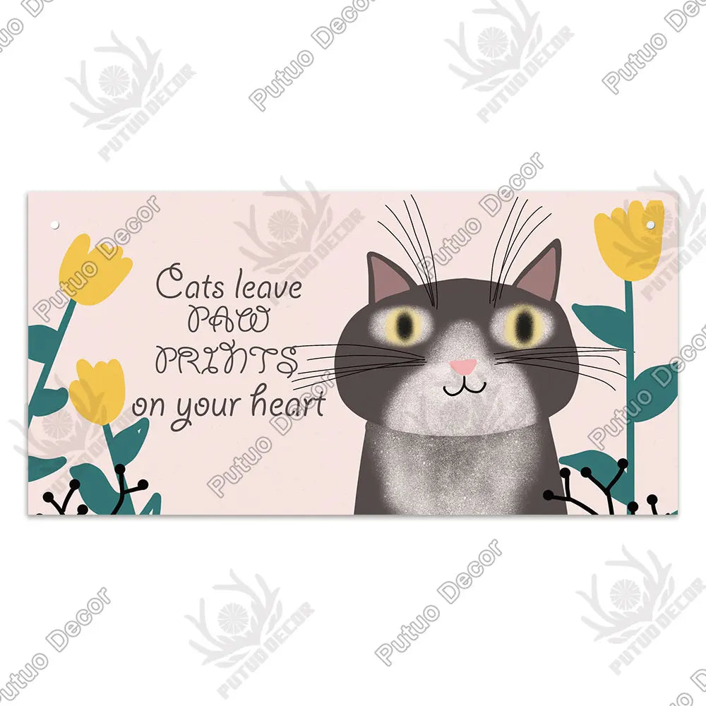 A watercolor illustration of a gray cat looking forward with yellow flowers and text that reads Cats leave paw prints on your