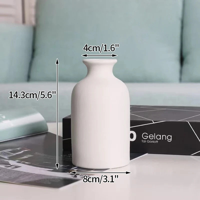 A white ceramic vase is shown on a table with various measuring tools and a black box in the background.