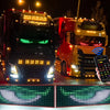 A black truck and a red truck are shown with bright LED light bars, next to a hand holding a smartphone displaying an app int