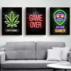 Tres impresiones de arte de juegos con neón enmarcadas, mostrando hojas de cannabis, texto 'game over' y gráficos de jugadore