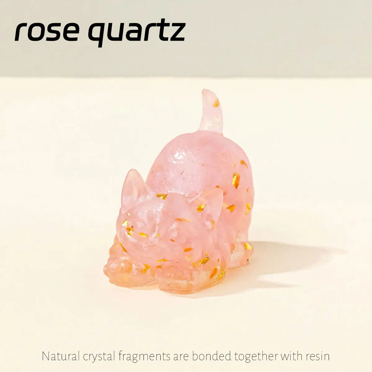 A pink rose quartz crystal fragment shaped like a crouching cat, embedded in resin.