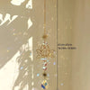 A hanging lotus flower crystal glass suncatcher with prism beads suspended by a gold chain.