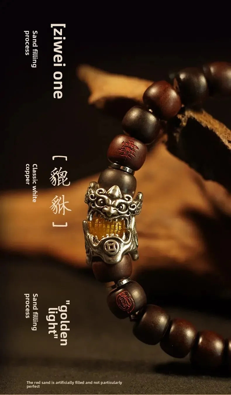A close-up of a dark brown wooden bracelet featuring semi-jade beads and an ornate metal charm.