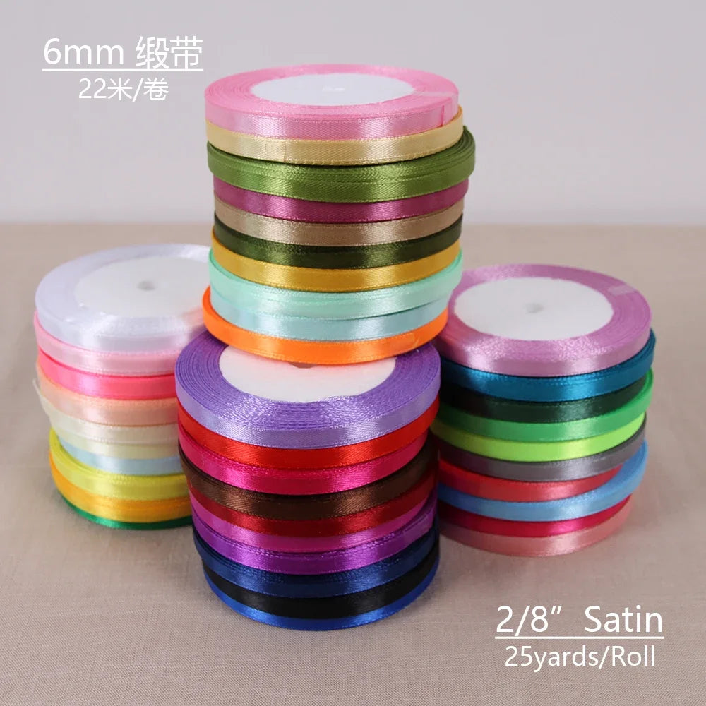 A stack of 6mm satin ribbon spools in various colors, including green, yellow, pink, and blue.