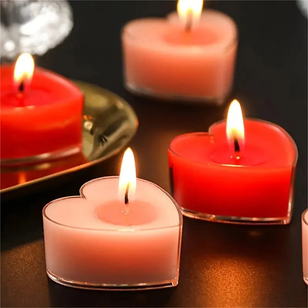 Un ensemble de bougies parfumées en forme de cœur, dans diverses nuances de rouge et de rose, brillant doucement.