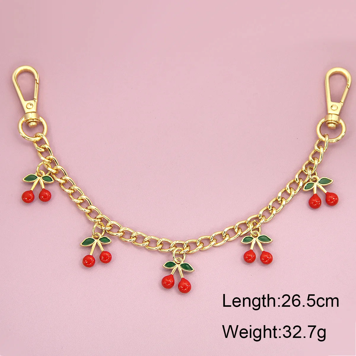 Gold chain necklace with red cherry charms and green leaves, measuring 26.5cm long.