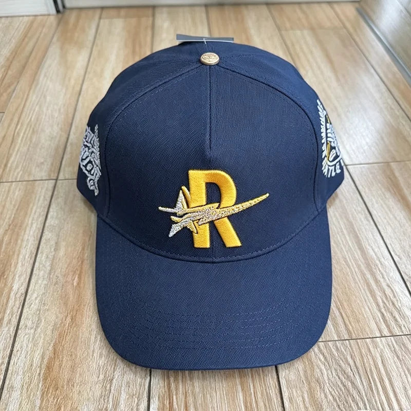 Navy baseball cap embroidered with a gold letter R and silver star design