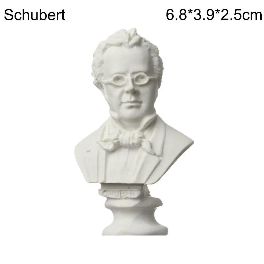 A white plaster bust miniature of a man, likely a classical figure, displayed on a pedestal.
