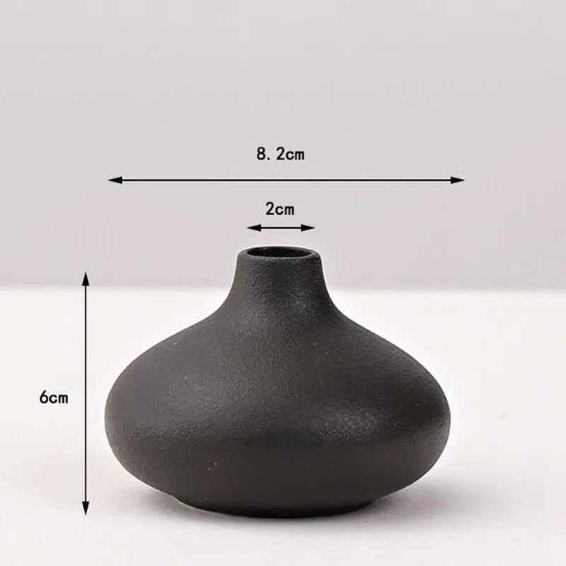 A matte black ceramic vase with a rounded, bulbous shape shown from above and the side.