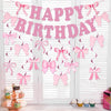 Glitter pink bow birthday banner strung across a white slatted door.