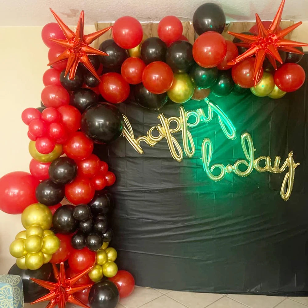 A vibrant arrangement of red, black, and gold star burst foil balloons used for party decor.