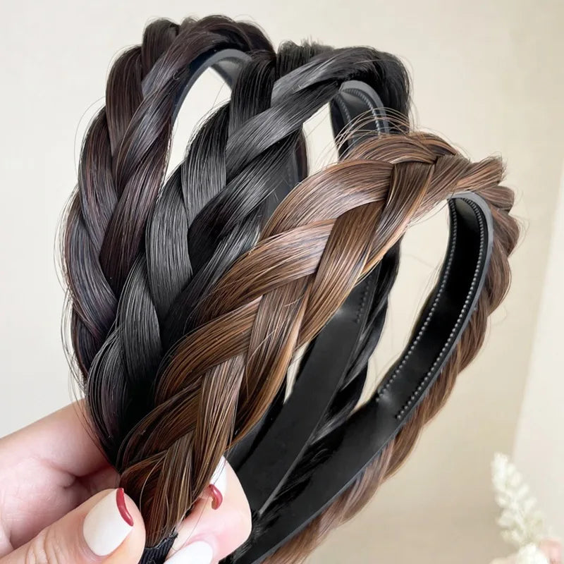 A hand holds several black and brown braided hair bands for fashion and party