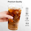 A hand holds a clear plastic cup with a lid filled with iced coffee or smoothie.
