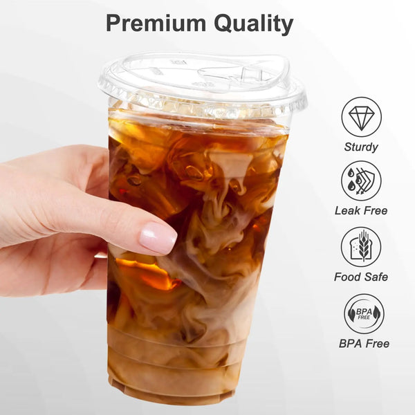 A hand holds a clear plastic cup with a lid filled with iced coffee or smoothie.
