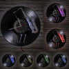 A collection of vintage vinyl record wall clocks featuring various colored records and clock faces mounted on a brick wall.
