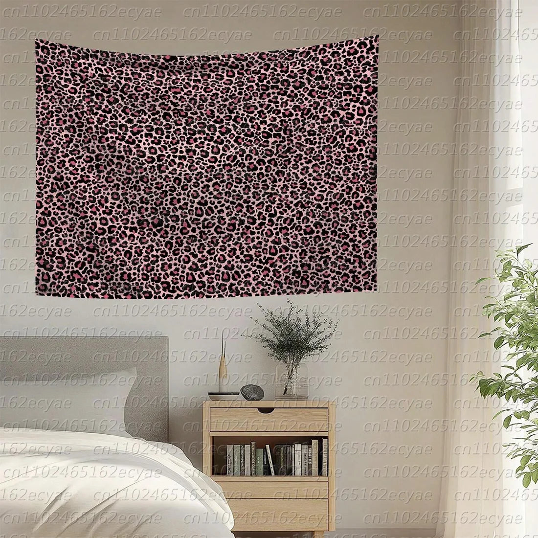 A large tapestry featuring a dense leopard print pattern in shades of pink and black.