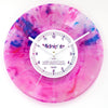 A pink and purple watercolor vinyl record wall clock with a white face and black hands.