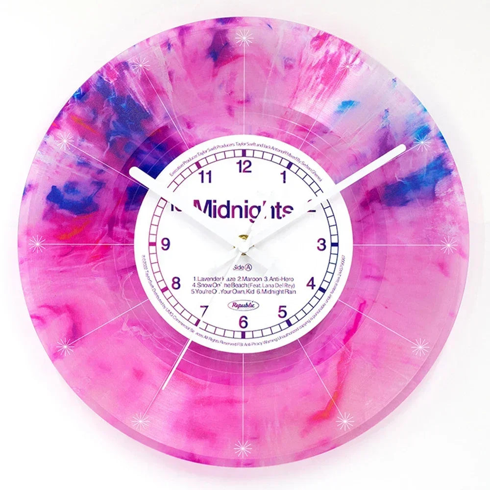 A pink and purple watercolor vinyl record wall clock with a white face and black hands.