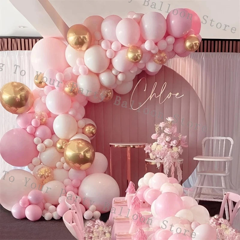 A pink and gold balloon garland arch display featuring various pastel balloons for parties.
