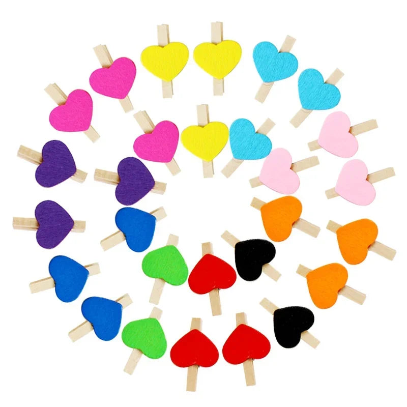 A collection of colorful mini wooden photo clips shaped like hearts arranged in a circle.