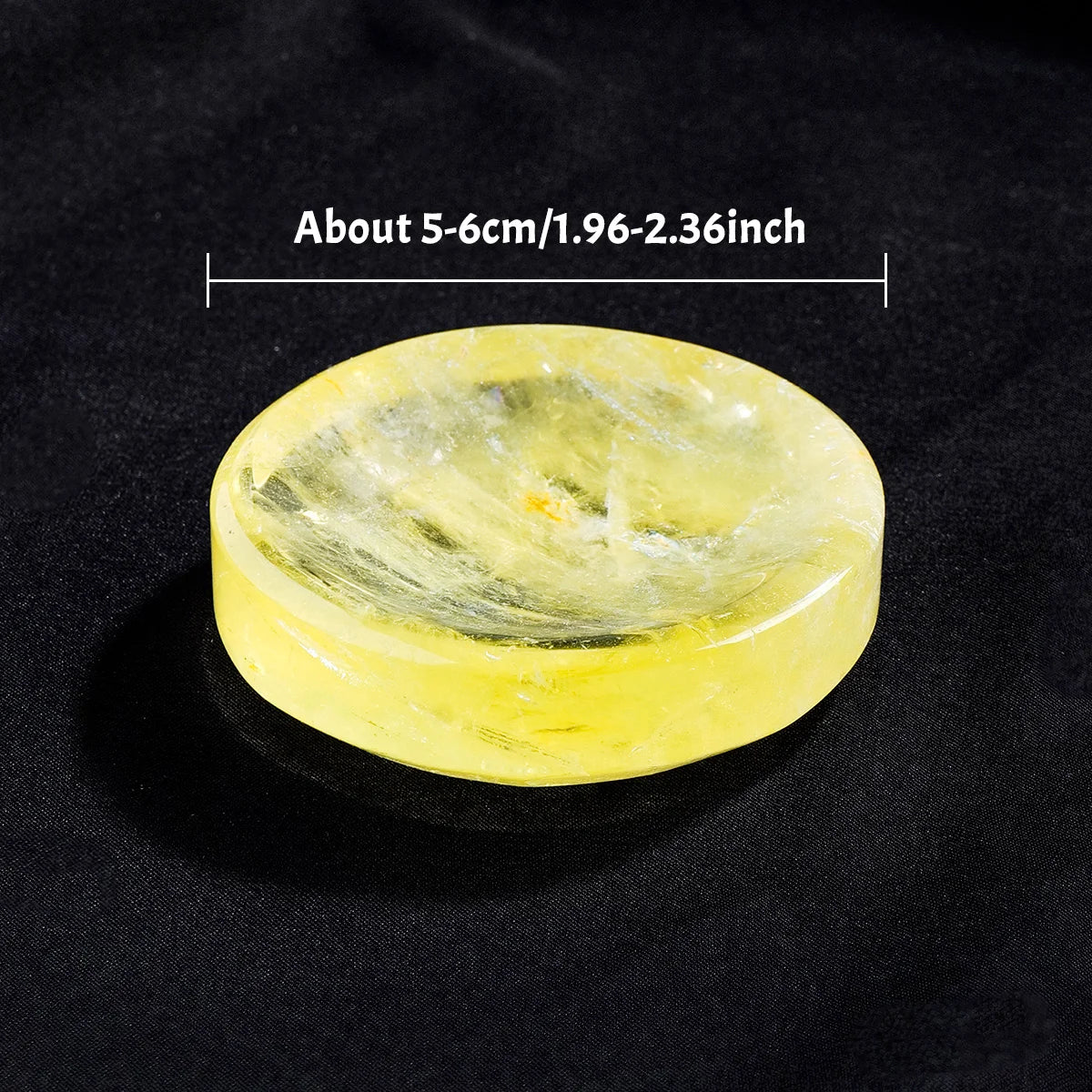 A round, translucent yellow citrine crystal bowl with natural inclusions, shown against a dark background.