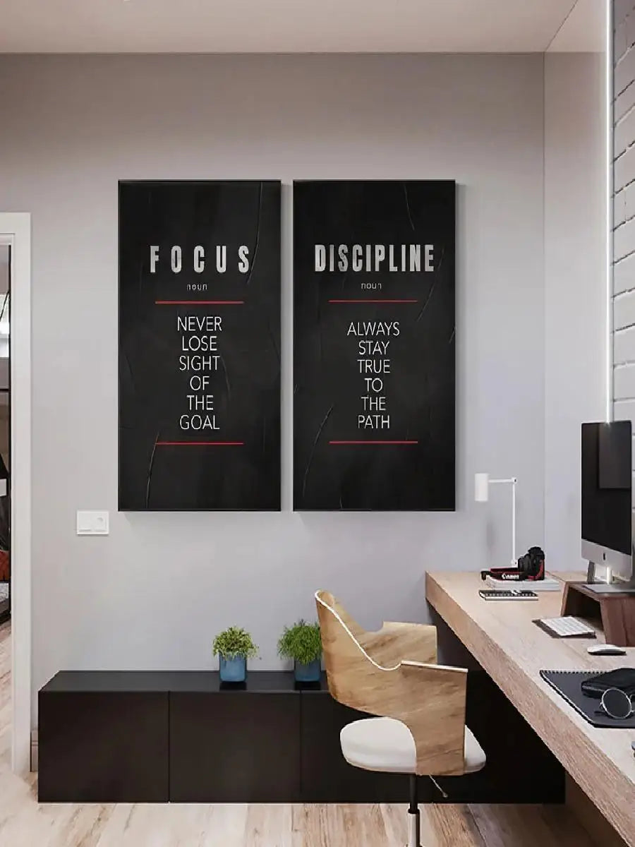 Two framed motivational canvas prints titled FOCUS and DISCIPLINE displayed on a white wall.