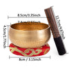 A handcrafted copper singing bowl set featuring a bowl, a mallet, and a red fabric band.