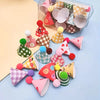 A collection of mini colorful party hat cake toppers in various patterns and colors arranged in a clear plastic container.