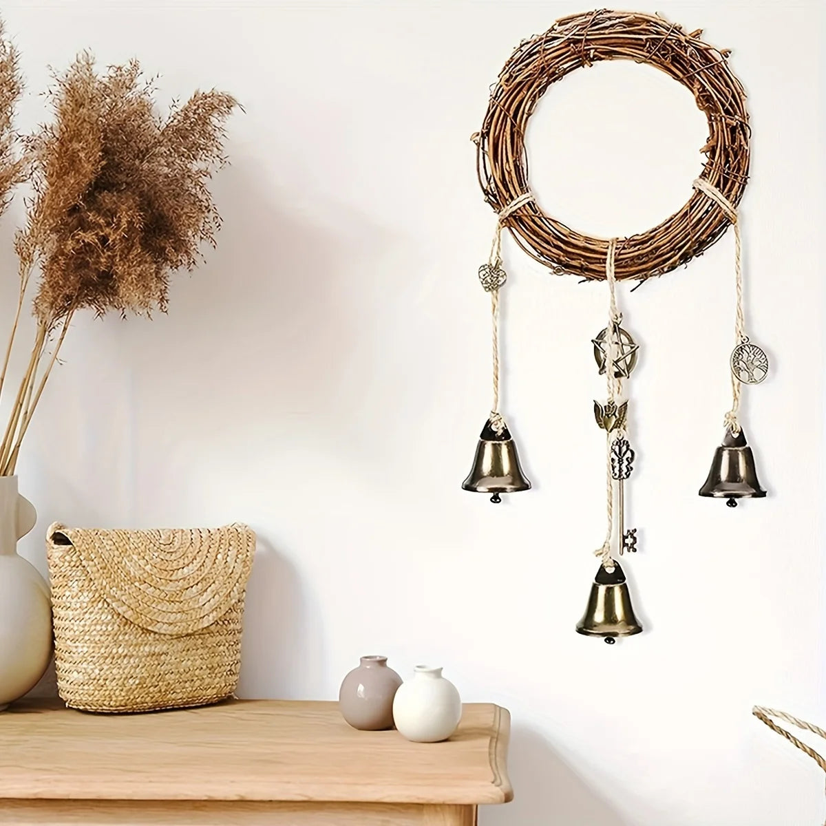A vintage wicker key bell hanging on a wall with decorative twine and small bells.