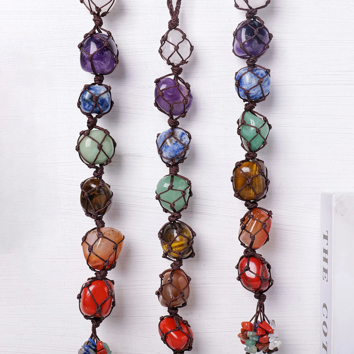 A string of natural crystal rolling stone pendants in various colors and shapes.