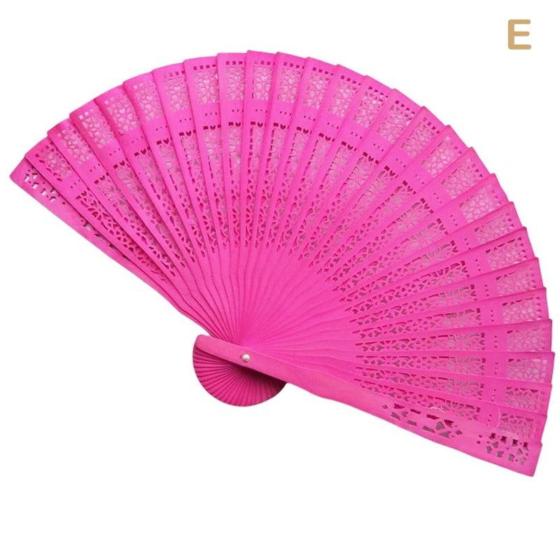 A bright pink hand carved bamboo folding fan shown open and angled.