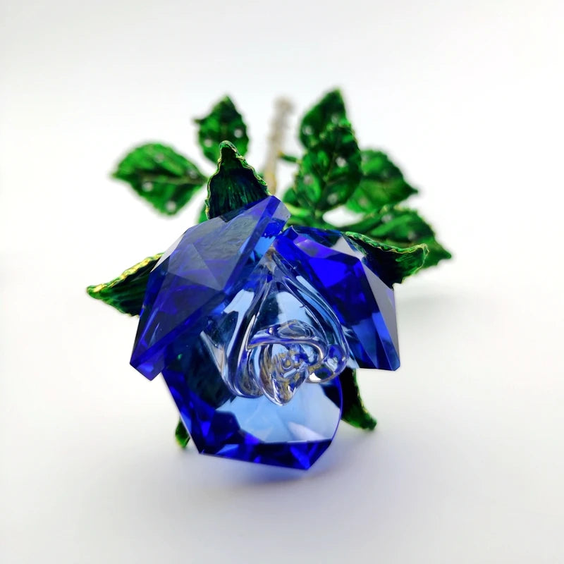 A handcrafted crystal glass rose vase with deep blue petals and golden leaves.