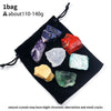 A set of natural crystals including purple, blue, red, white, and green stones displayed on a black fabric bag.