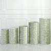 A row of four cylindrical green spandex stands used for wedding and event decor on a light wooden floor.