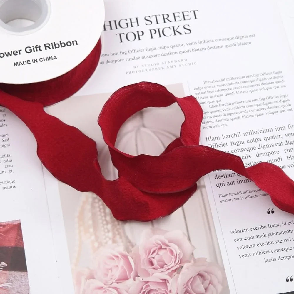 A deep red decorative fishtail yarn ribbon is shown against a white background.