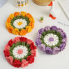 Three hand-crocheted rose flower coasters in orange, red, and purple displayed on a white surface.