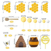 A set of bee-themed cake toppers including honeycomb decor, a honey jar, and various yellow and brown shapes.