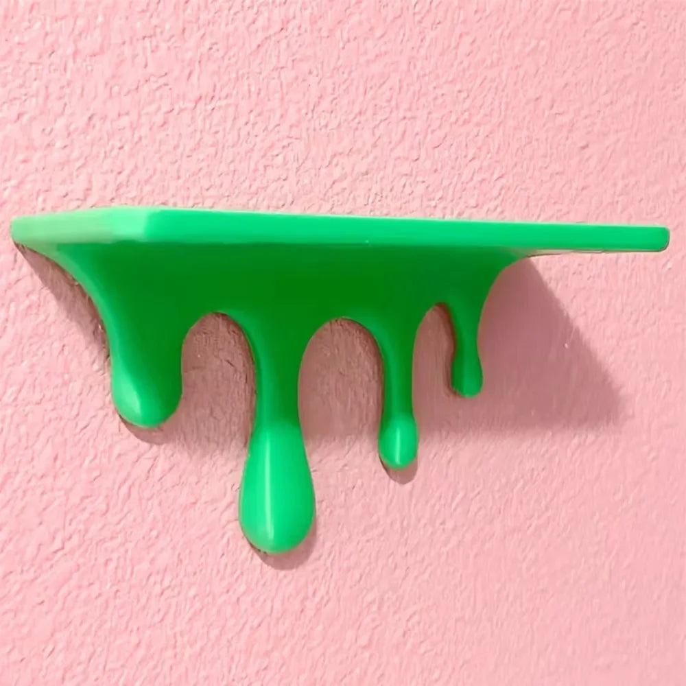 A bright green liquid drip effect on a pink wall, showcasing a 3D printed floating shelf design.
