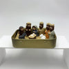 A hand-painted mini nativity set featuring figures of Mary Joseph and baby Jesus in a gold tin storage box.