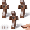 Three handcrafted black walnut cross shapes with heart engravings shown against a white background.