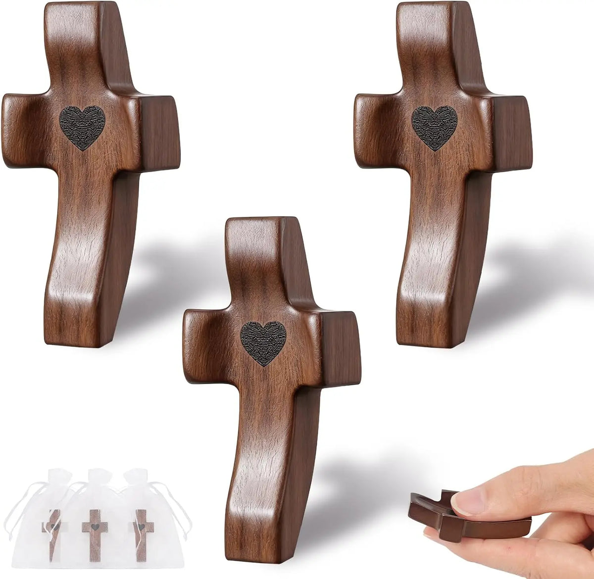 Three handcrafted black walnut cross shapes with heart engravings shown against a white background.
