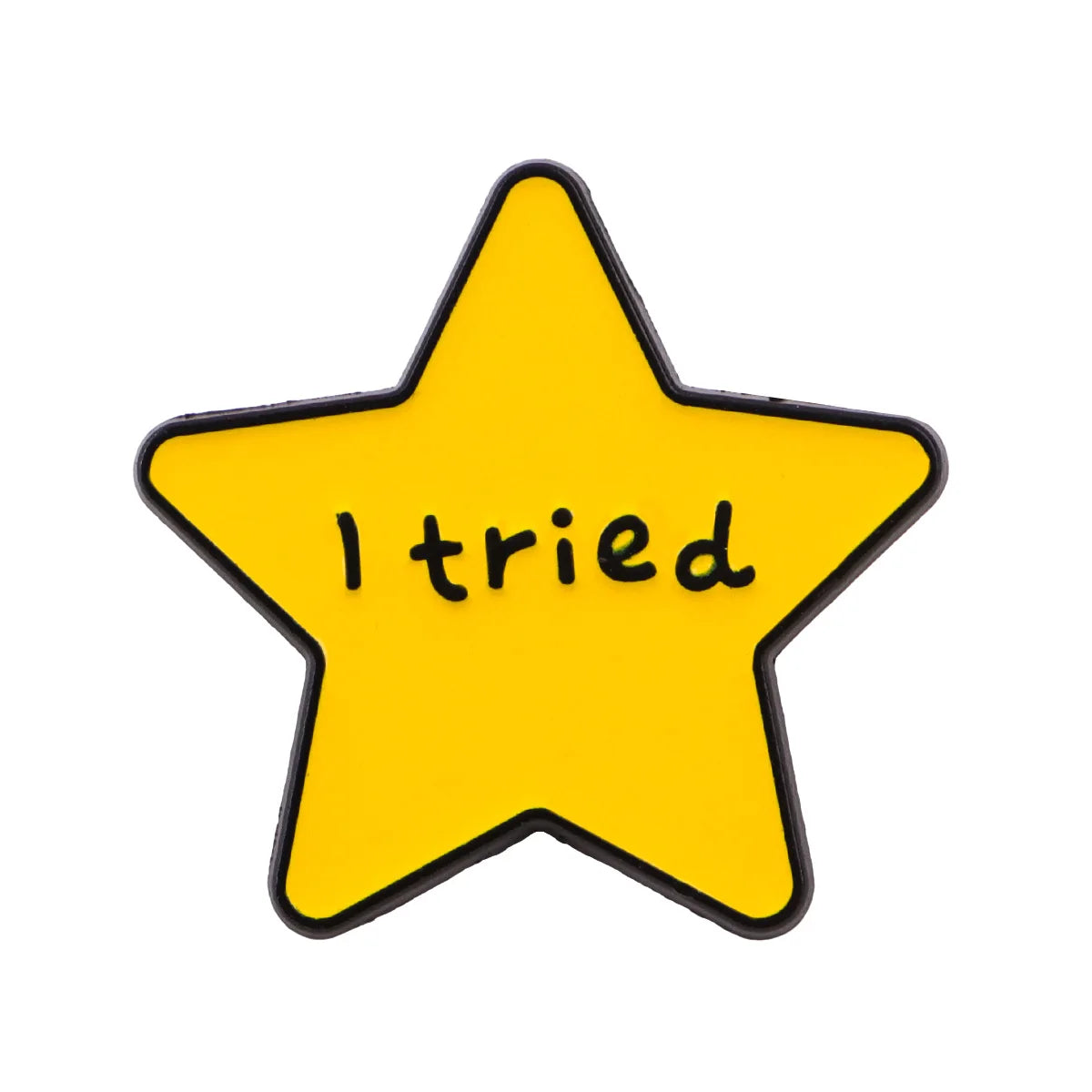 A yellow star enamel pin with the text I tried on it.