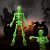 A bright green plastic skeleton figurine standing in front of a carved pumpkin and spooky background.