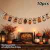 A string of vintage wooden Halloween decorations featuring pumpkins, ghosts, and moons displayed on a wall.