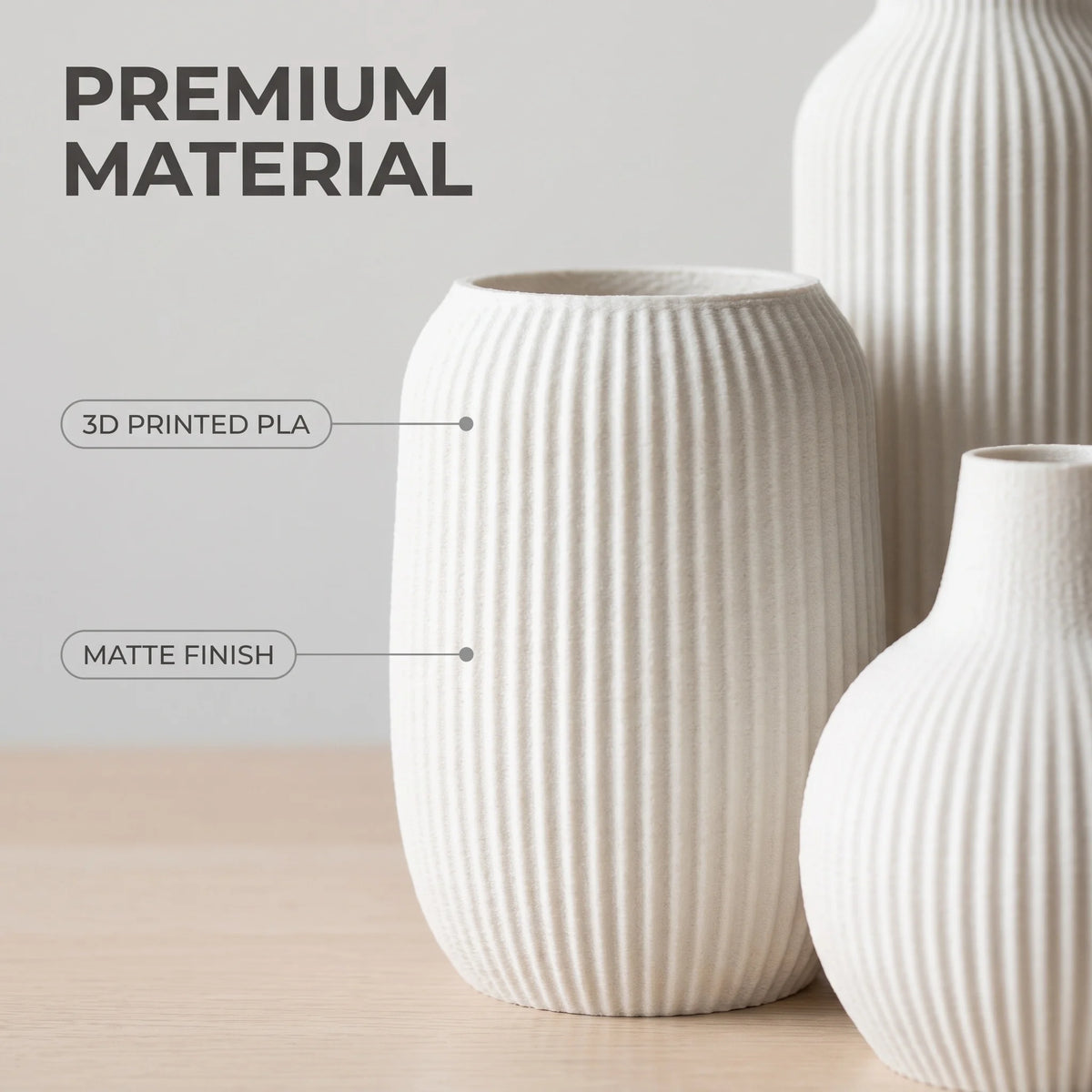 A set of three white ceramic vases with a vertical ribbed texture, showcasing premium material and matte finish.