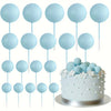A collection of light blue foam ball cake toppers on sticks for party decorations
